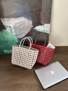 Dettaglio della borsa intrecciata con manici rotondi e struttura a rete traforata beige