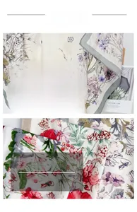 Detail of floral print silk scarf featuring red roses, purple flowers and fine stitching