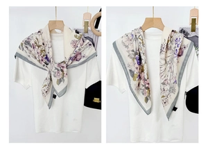 Detail of floral printed silk scarf tied over a white shirt with vintage flower patterns