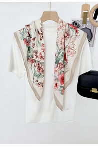 Detailed view of a vintage floral silk scarf styled over a white knit short-sleeve top