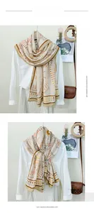 Detail of soft imitation cashmere scarf featuring orange ethnic geometric patterns
