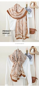 Detail of geometric pattern imitation cashmere scarf worn as a shawl and a neck wrap