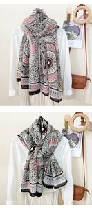 Detail of a geometric print scarf featuring leaf patterns and black-red-white color blocks