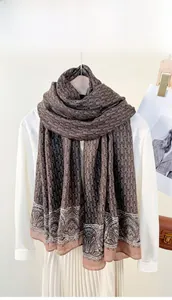 Detail of vintage chain print scarf with brown paisley pattern and pink border on white shirt