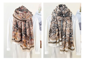 Close-up of bohemian paisley patterns on two long scarves in warm and cool tones