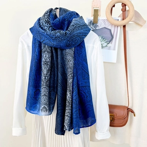 Blue paisley gradient ethnic scarf displayed elegantly with beach travel accessories