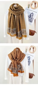 Close-up of mustard yellow long scarf with elegant chain print and paisley patterns