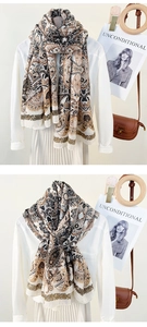 Detail of bohemian scarf with vintage floral patterns and fringe edge shown on a model
