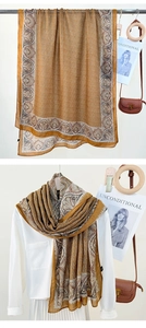 Detail of tan paisley print long scarf styled with white shirt and brown crossbody bag
