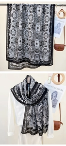 Detail of long scarf with black and white Paisley pattern on lightweight fabric