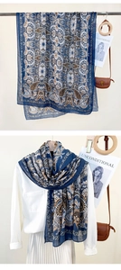 Detail of blue paisley long scarf showing semi-transparent texture and retro pattern