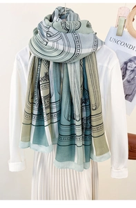 Detail of mint green and yellow patterned silk scarf styled on a white shirt