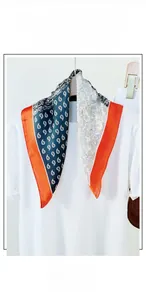 Detailed shot of mulberry silk scarf with paisley patterns and elegant orange borders