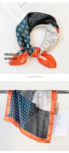Detail of silk scarf showing paisley and houndstooth patterns with orange borders