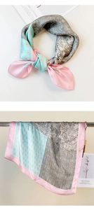 Detail of silk scarf with pink and blue paisley floral patterns and satin luster finish