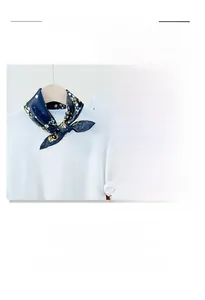 Detailed view of dark blue silk scarf with yellow floral print and smooth texture