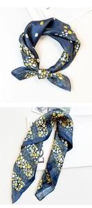 Detail of silk scarf with floral print tied in a knot and draped over magazines