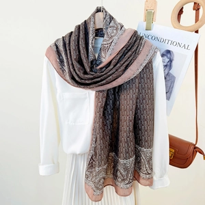 Retro chain and paisley print scarf in brown draped over a white shirt for a chic look