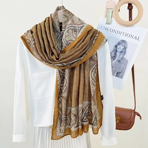 Elegant long paisley scarf for women in ginger and earth tones draped on a white shirt