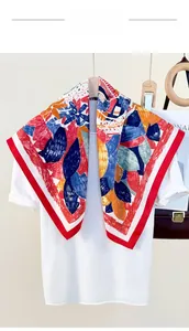 Detail of colorful floral silk scarf with vibrant red borders over white t-shirt