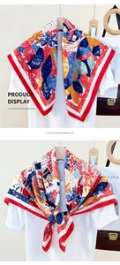 Detail of multi-color imitation cashmere scarf with vibrant floral print and red border