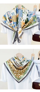 Detail of silk-like satin square scarves featuring floral and leaf print on hangers
