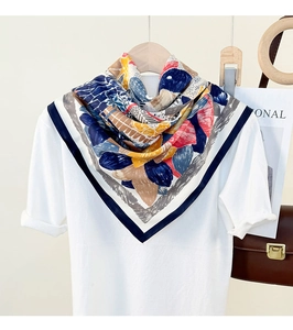 Silky silk-like square scarf with colorful geometric print draped over a white t-shirt