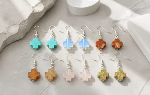 Close-up of cross-shaped semi-precious stone earrings with silver fishhook ear wires