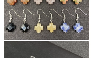 Macro shot of assorted natural stone cross earrings in black obsidian and marble finishes