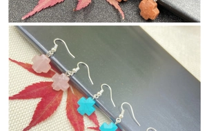 Detailed macro view of crystal cross earrings in pink, blue, and brown stone textures
