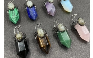 Macro detail of eight assorted hexagonal crystal moon pendants on black background