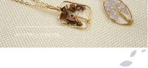 Macro detail of handmade Tree of Life pendants with Tiger Eye and Amethyst stones
