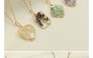 Detail view of handmade tree of life necklaces with various natural crystal stones