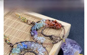 Detail of handmade Tree of Life car charm with natural crystals and copper wire wrapping