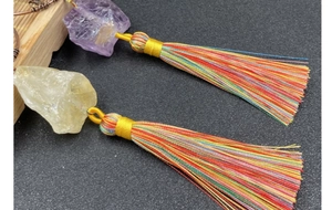 Detail of handmade Tree of Life car charm with natural crystals and vibrant silk tassels