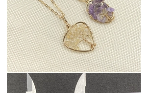 Detailed close-up of Tree of Life heart pendant necklace with purple and yellow crystals