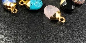 Macro shot of assorted semi-precious stone oval pendants with 18K gold plated caps