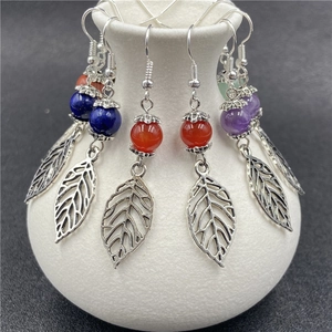 Silver leaf earrings with semi-precious agate beads on white ceramic display