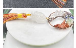 Close-up of handmade Tree of Life car charm with natural crystals and colorful tassels