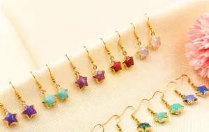 Close-up of star-shaped crystal drop earrings in multiple colors with gold-plated hooks
