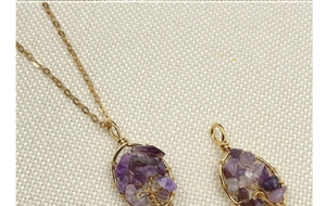 Macro detail of handmade purple crystal Tree of Life pendant with delicate gold chain
