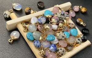 Macro shot of colorful semi-precious stone pendants with gold plated caps on a bamboo mat