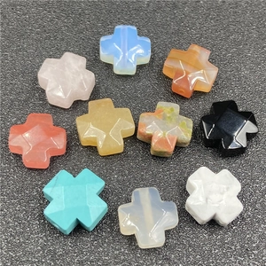 Detailed view of polished cross-shaped natural stone beads with faceted crystal surfaces