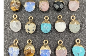 Macro display of faceted semi-precious stone pendants with gold plated tops in various colors