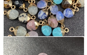 Close-up of faceted semi-precious stone pendants with gold plated edges and loops
