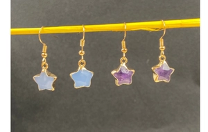 Detailed view of star-shaped crystal drop earrings in blue and purple gemstone colors