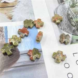 Macro shot of cross-shaped unakite natural stone beads for DIY jewelry making