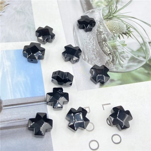 Detailed view of polished black onyx cross beads with side holes for DIY jewelry