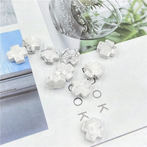 Macro view of cross-shaped white marble texture loose beads with holes for DIY jewelry