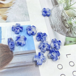 Close-up of blue and white stone cross beads for DIY jewelry making and crafts